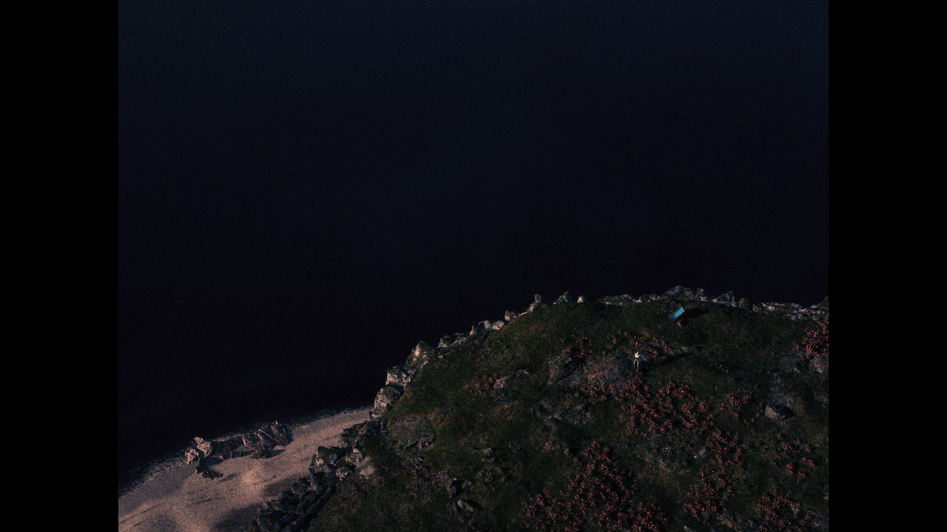 Visão por cima da divisa entre uma falésia e o mar.